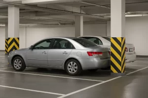 پارکینگ آپارتمان با دو خودروی سواری که یکی در ردیف دوم و به‌صورت مزاحم پارک شده است؛ محیط روشن، ستون‌های سفید و زرد، و فضای تمیز و مدرن پارکینگ زیرزمینی.