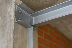  اتصال نبشی فلزی گالوانیزه در گوشه دیوار بتنی و آجری که نشان‌دهنده اجرای صحیح نبشی‌کشی در ساختمان است.
