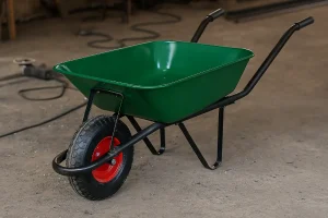 فرغون سبز فلزی با شاسی مشکی و چرخ قرمز در کارگاه ساخت و ساز، قرارگرفته روی زمین سیمانی**
